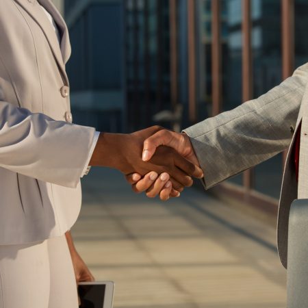 African American businesswoman shaking hands with male partner. Closeup of business colleagues handshake. Corporate meeting concept